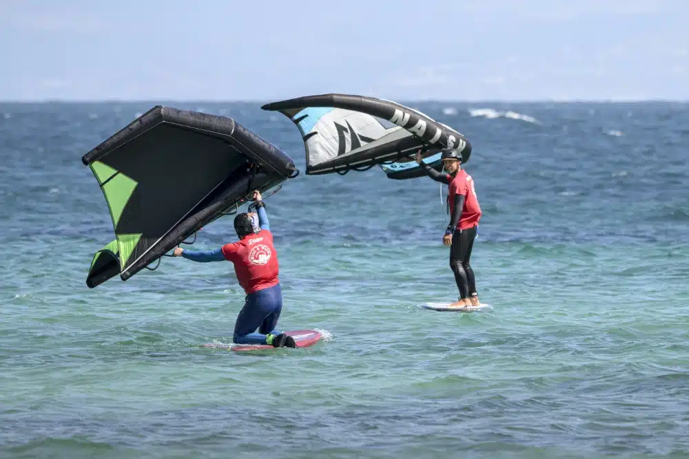 Dos alumnos aprendiendo Wing Foil en una clase dual en Tarifa